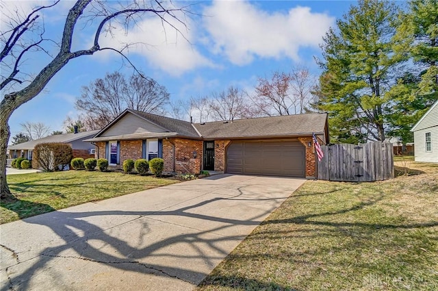 view of front of home with fence, driveway, an attached garage, a front lawn, and brick siding