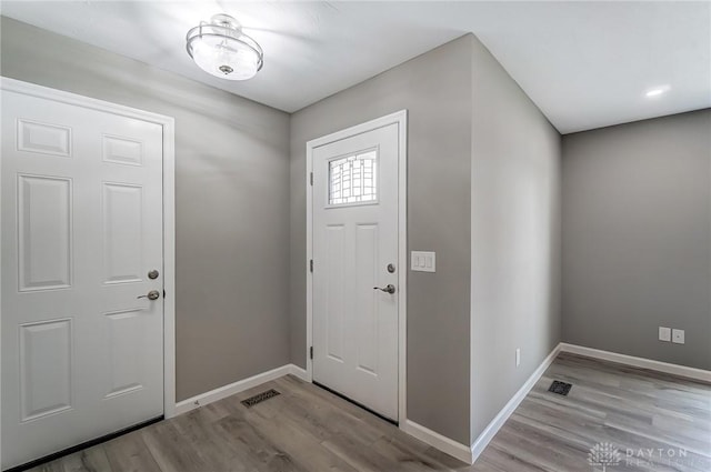 foyer featuring baseboards and wood finished floors