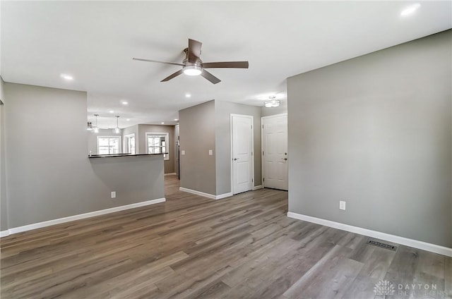 unfurnished living room featuring visible vents, baseboards, recessed lighting, wood finished floors, and a ceiling fan