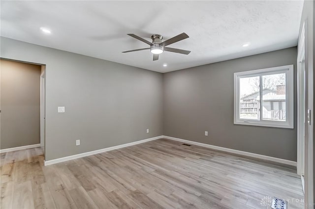 empty room with visible vents, baseboards, light wood-style floors, and ceiling fan