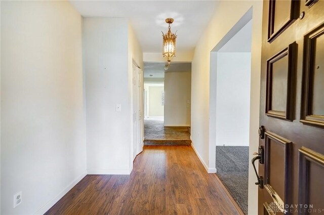 hall with dark wood-style floors and baseboards