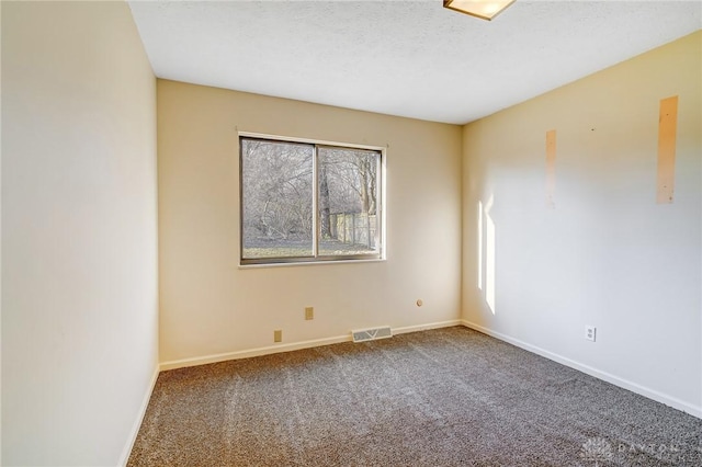 unfurnished room featuring baseboards, carpet floors, a textured ceiling, and visible vents