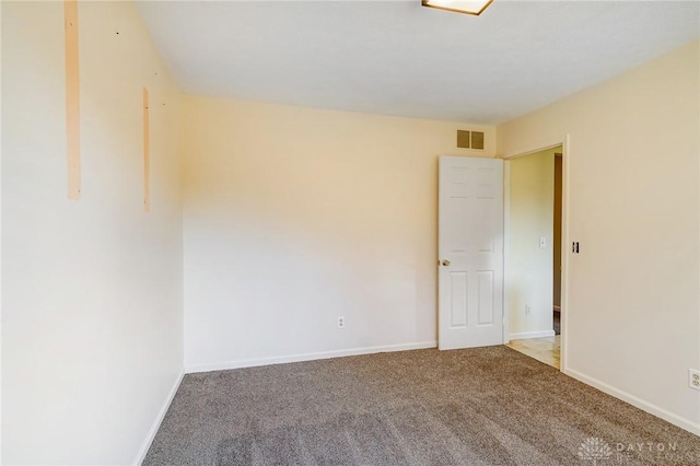 empty room with visible vents, baseboards, and carpet floors