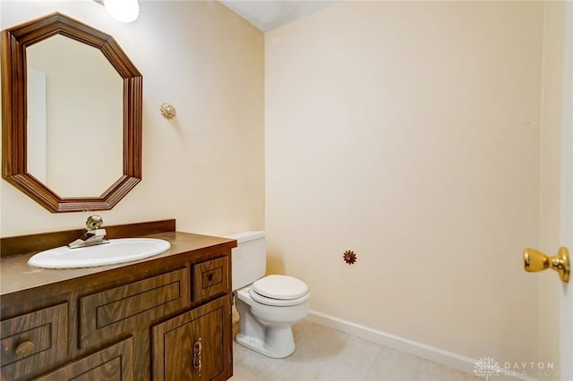 bathroom with baseboards, toilet, vanity, and tile patterned flooring