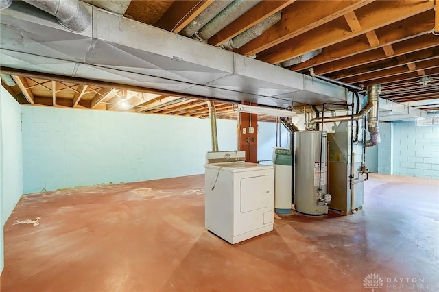 unfinished basement featuring heating unit, gas water heater, and washer / clothes dryer