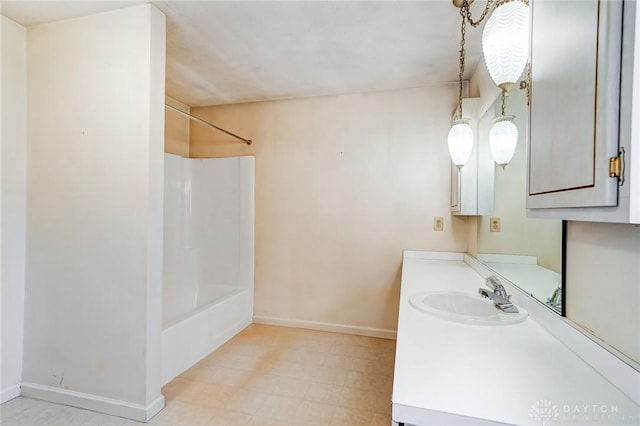 bathroom with tile patterned floors, baseboards,  shower combination, and vanity