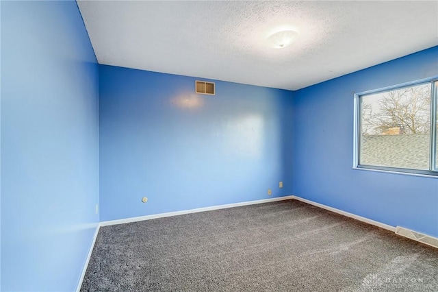 empty room with visible vents, baseboards, a textured ceiling, and carpet flooring