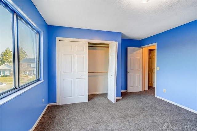 unfurnished bedroom with a closet, baseboards, carpet, and a textured ceiling