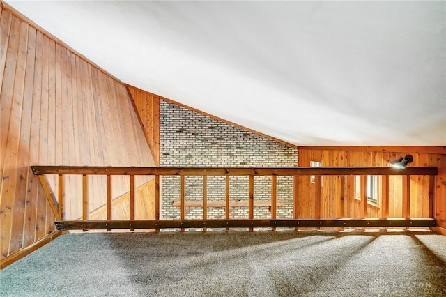 bonus room with carpet flooring, wooden walls, and vaulted ceiling