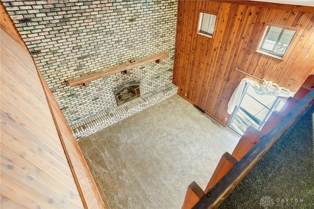 carpeted living room featuring wooden walls