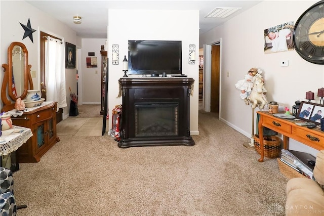 carpeted living area with a glass covered fireplace, baseboards, and visible vents