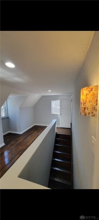 stairway with lofted ceiling, recessed lighting, and wood finished floors