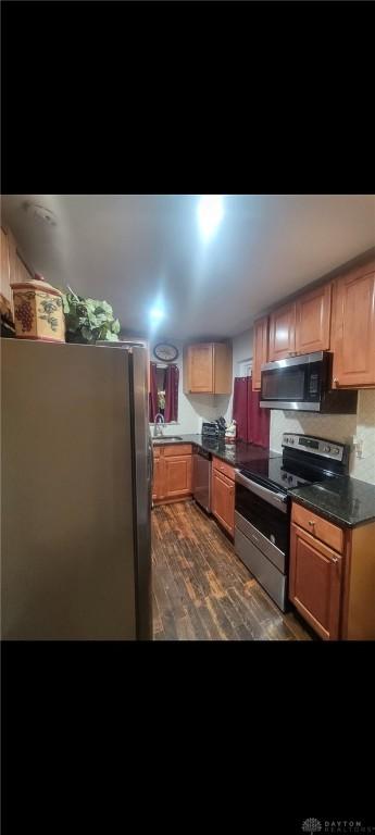 kitchen featuring dark countertops, dark wood-style floors, and stainless steel appliances