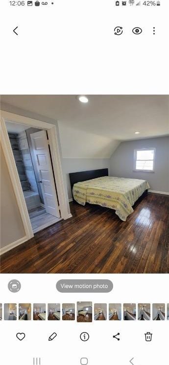 unfurnished bedroom featuring dark wood-type flooring and vaulted ceiling