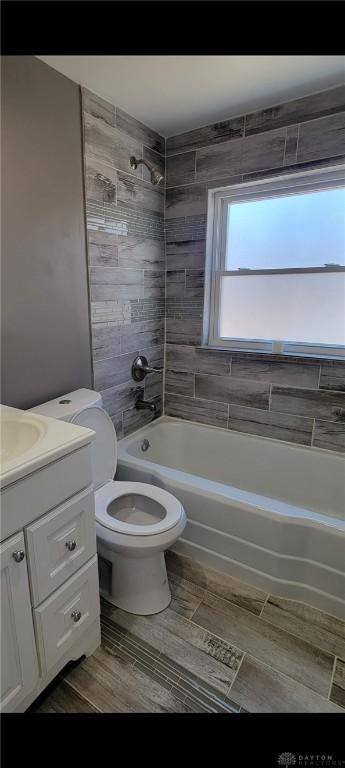 bathroom with vanity, toilet, tub / shower combination, and wood finish floors