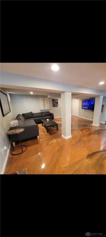 unfurnished living room with baseboards and wood finished floors