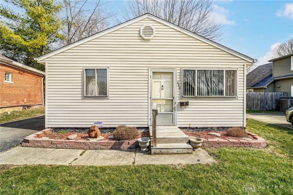 view of front of house with a front lawn and fence