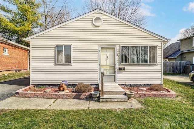 view of front of house with a front lawn and fence