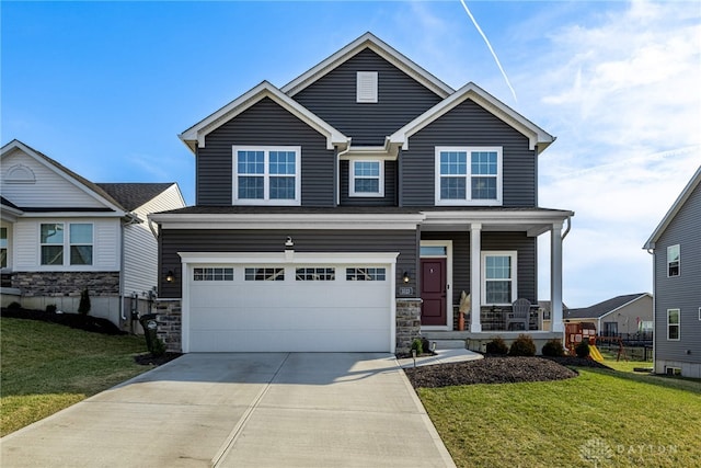 view of front of home featuring stone siding, driveway, a porch, and a front yard