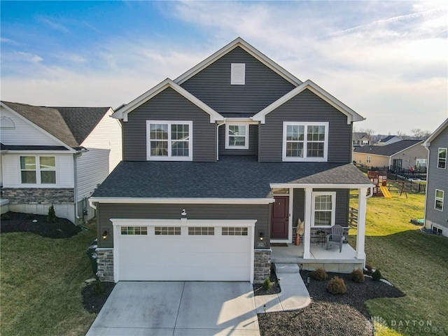 view of front of house featuring a porch, concrete driveway, a front yard, and roof with shingles