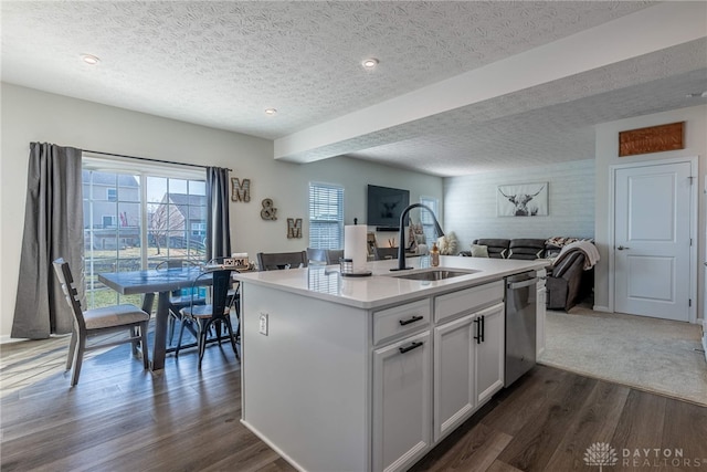 kitchen featuring a sink, dark wood-type flooring, open floor plan, white cabinets, and stainless steel dishwasher