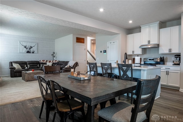 dining space with dark wood-type flooring, recessed lighting, and a textured ceiling