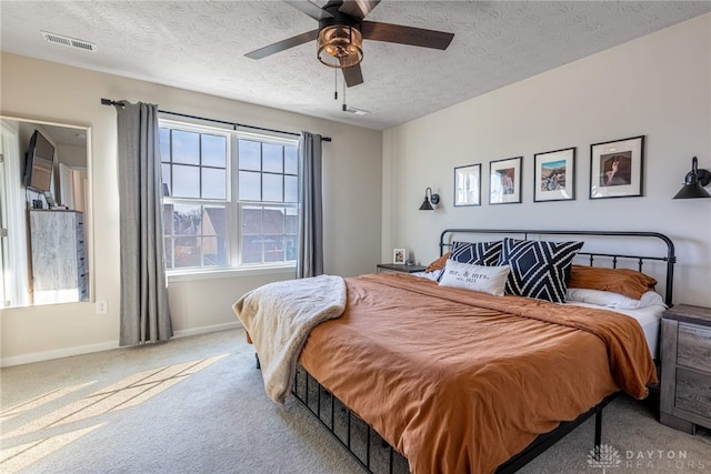 bedroom with visible vents, a textured ceiling, carpet, baseboards, and ceiling fan