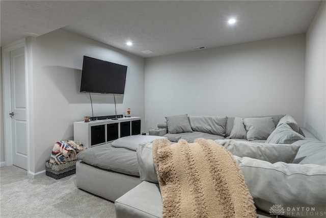 living room featuring baseboards, visible vents, recessed lighting, a textured ceiling, and light carpet