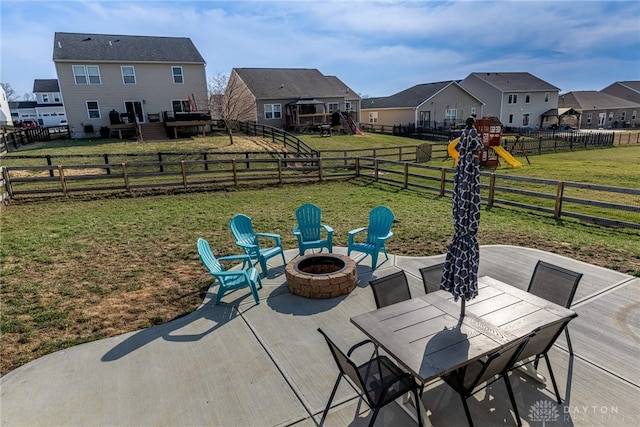 view of patio / terrace with a fenced backyard, a playground, an outdoor fire pit, a residential view, and a wooden deck