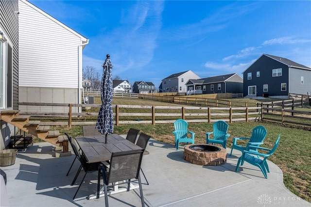 view of patio / terrace featuring outdoor dining area, a residential view, a fire pit, and fence