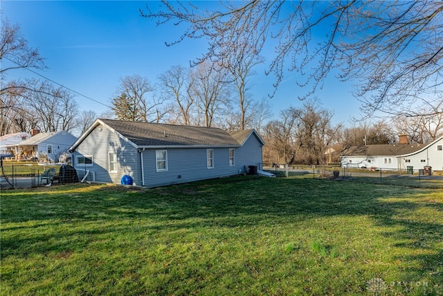 view of side of home featuring a yard and fence