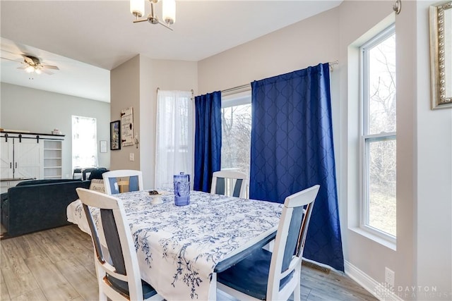 dining room featuring a ceiling fan, plenty of natural light, light wood-style floors, and baseboards