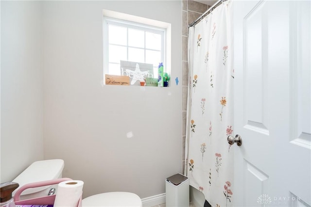 bathroom featuring curtained shower and toilet