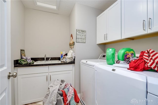 laundry area featuring cabinet space, washing machine and dryer, and a sink