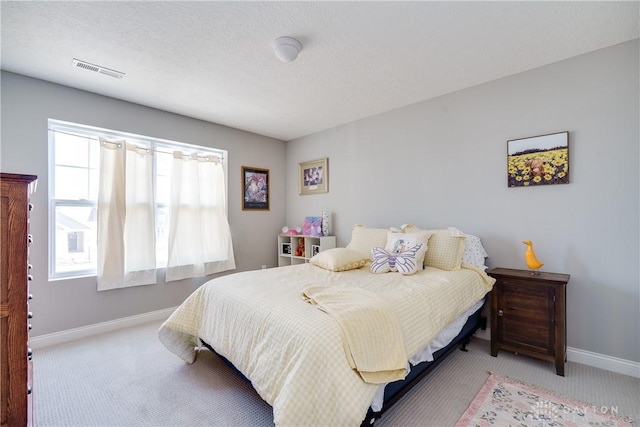 bedroom with visible vents, a textured ceiling, baseboards, and carpet