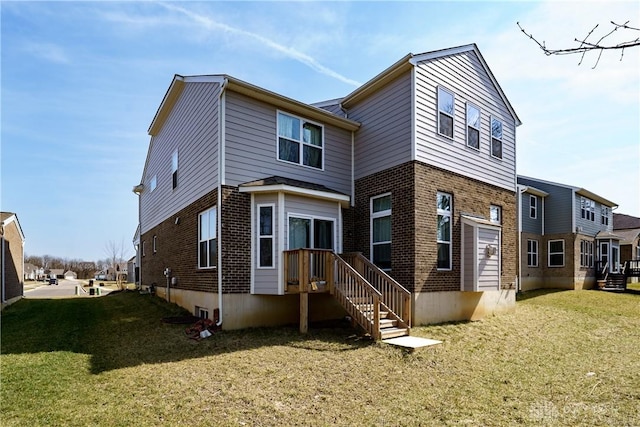 back of property with brick siding and a yard