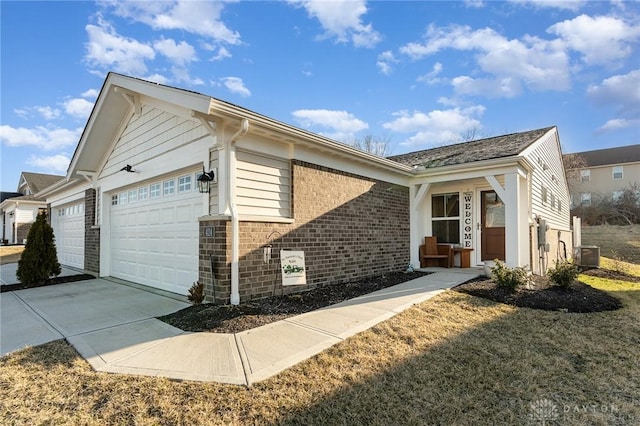 view of property exterior featuring brick siding, cooling unit, an attached garage, and concrete driveway