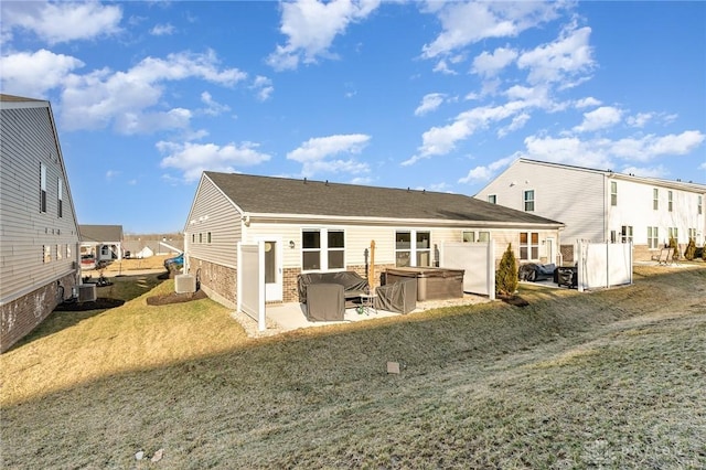 rear view of house with brick siding, cooling unit, a hot tub, and a patio