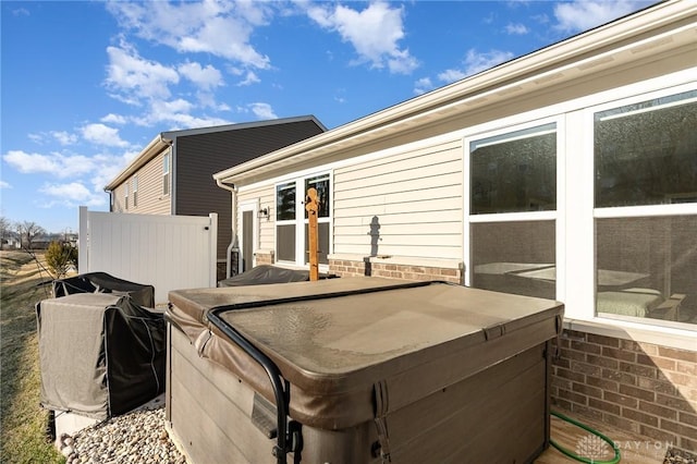 deck with grilling area and a hot tub