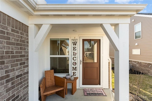 entrance to property featuring brick siding