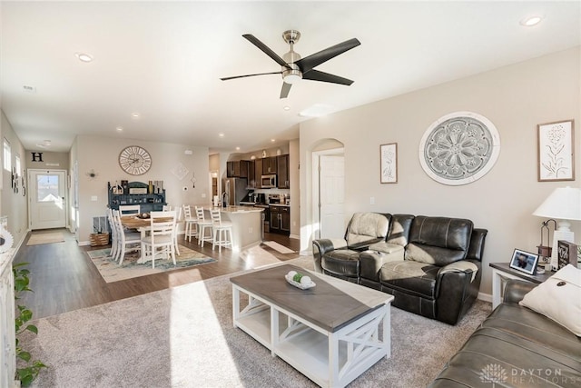 living room featuring light wood-style flooring, recessed lighting, a ceiling fan, and baseboards