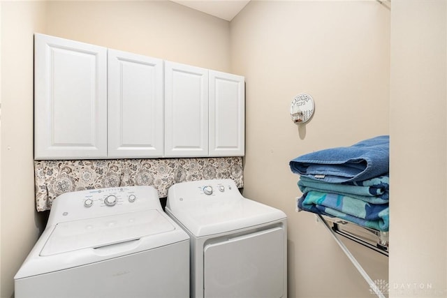 washroom with cabinet space and washer and clothes dryer