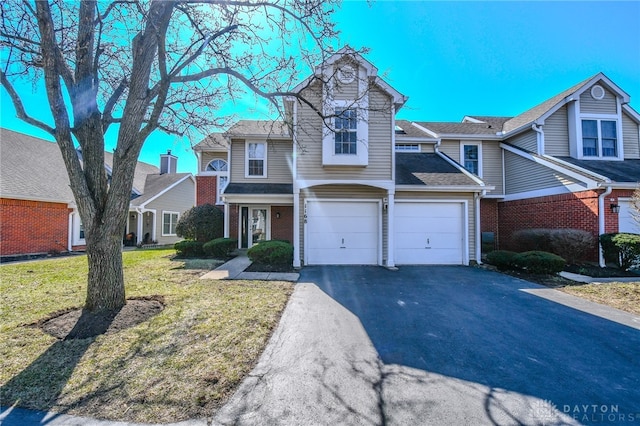 townhome / multi-family property with a garage, brick siding, a front lawn, and aphalt driveway