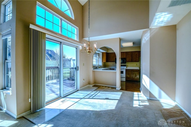 interior space featuring baseboards, carpet, visible vents, and a chandelier