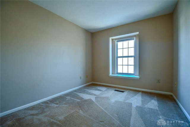 unfurnished room with visible vents, baseboards, and carpet floors