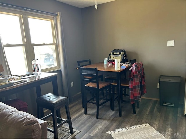 dining space featuring baseboards and wood finished floors