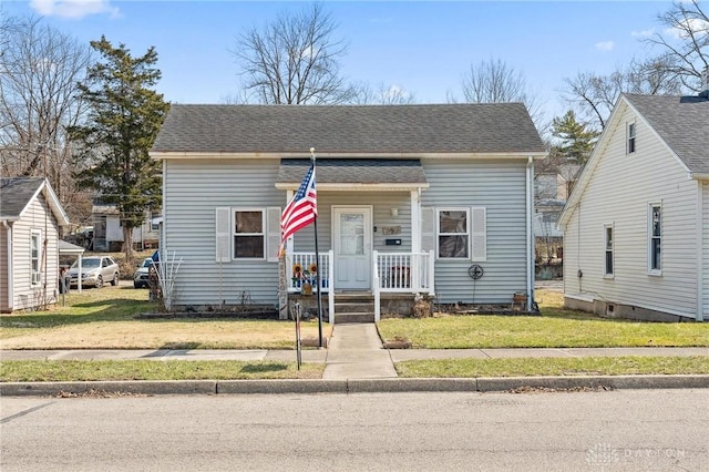 bungalow-style house with a front yard, covered porch, and a shingled roof