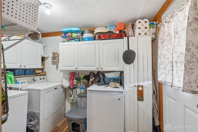 washroom featuring washer and dryer, wood finished floors, and cabinet space