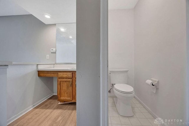 bathroom with tile patterned floors, toilet, vanity, and baseboards