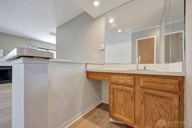 bathroom featuring visible vents, baseboards, recessed lighting, wood finished floors, and vanity